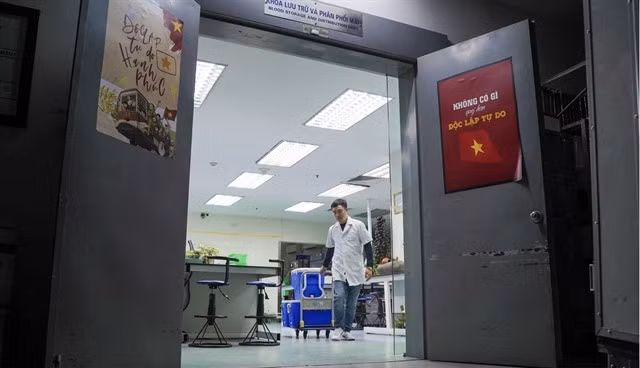 Tôt le matin, le pharmacien Nguyên Hoàng Minh prépare des conteneurs de sang et de produits sanguins au sein du service de stockage et de distribution du sang du Centre national de transfusion sanguine. Photo : dantri.com.vn