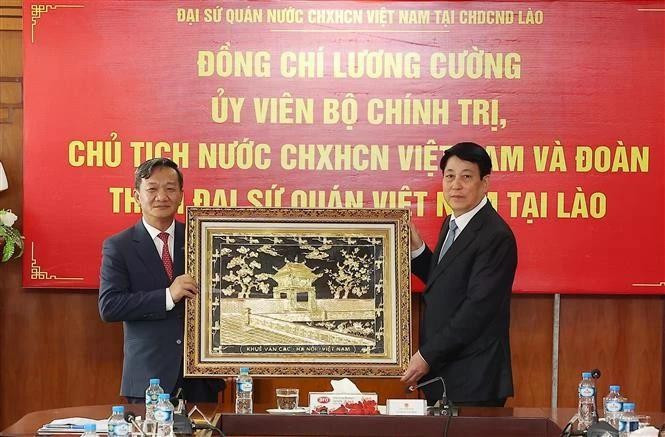 Le président Luong Cuong offre un tableau de Khue Van Cac (Pavillon de la Constellation des Lettres), faisant partie du temple de la Littérature, à l’ambassade du Vietnam au Laos. Photo : VNA