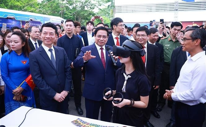 Le Premier ministre Pham Minh Chinh avec des étudiants participant au lancement officiel du mouvement national intitulé « La nation entière s'inspire de l'innovation et de la transformation numérique » à Hanoï. Photo: VNA