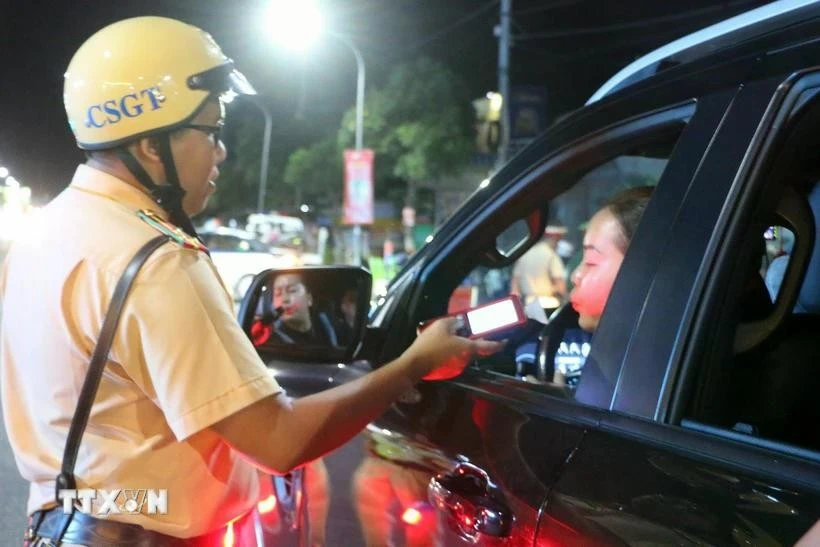 La police de la circulation de la ville de Long Xuyên contrôle au hasard le taux d'alcoolémie des usagers de la route. Photo: VNA