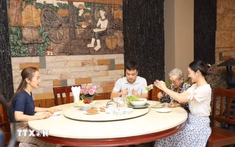 Un repas familial chaleureux selon la tradition vietnamienne dans la famille de Mme Nguyen Thi Nuong. Photo : VNA