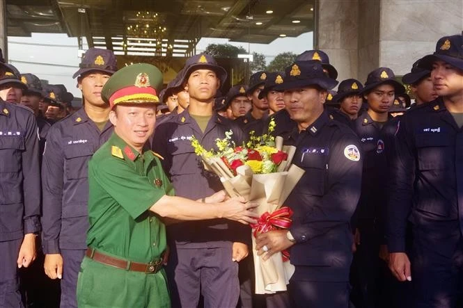 Le colonel Nguyên Dinh Chuân, commissaire politique du commandement militaire de la province de Binh Duong, offre des fleurs en guise de remerciement à la délégation cambodgienne. Photo: VNA