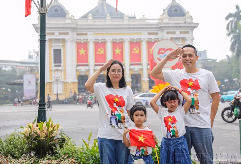 Une famille prend une photo de souvenir à Hanoi à l'occasion du 50e anniversaire de la libération du Sud et de la réunification du pays (30 avril 2025). Photo : VNA