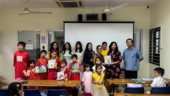 La vice-ministre des Affaires étrangères Lê Thi Thu Hang offre des livres aux enseignants et aux élèves d’une classe de langue vietnamienne. Photo : VNA