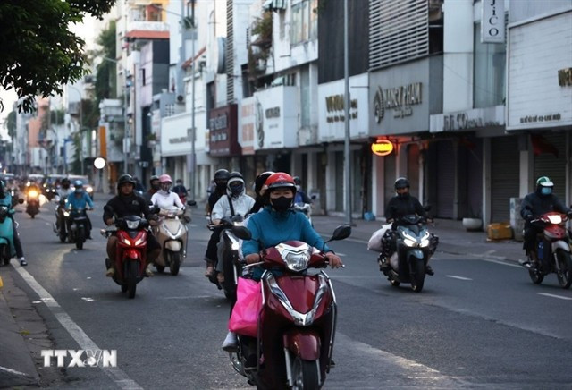 Des habitants, vêtus chaudement, se déplacent dans la rue Hô Van Huê, dans le quartier de Duc Nhuân, à 6h20 le 9 janvier, pour se rendre au travail. Photo : VNA