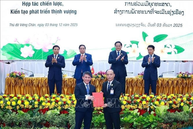 Lors de la signature et de l'échange d'accords de coopération, à Vientiane, le 3 décembre. Photo : VNA