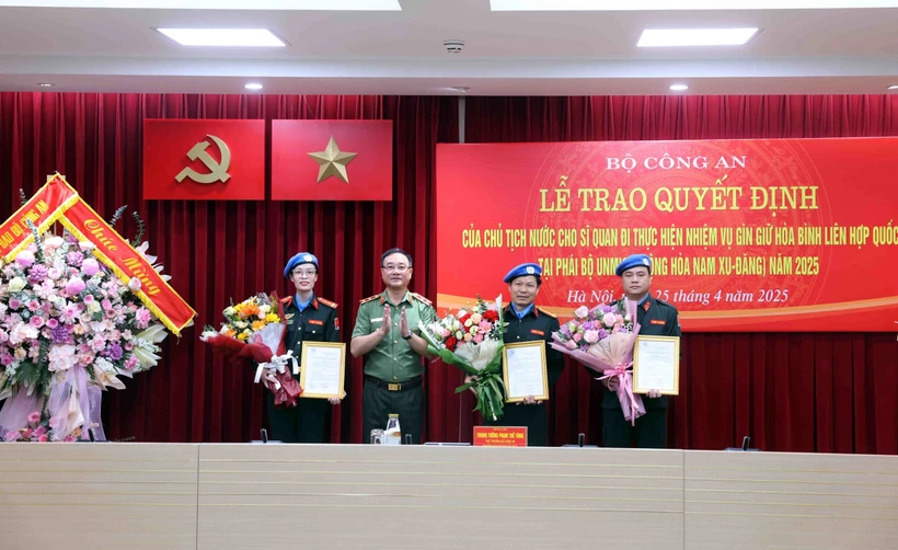 Le vice-ministre de la Sécurité publique, Pham Thê Tùng (2e à partir de la gauche) remet la décision du président de la République aux officiers. Photo: VNA