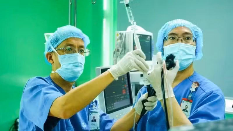 Le professeur associé Le Thuong Vu (à gauche) effectue une bronchoscopie avec échographie endobronchique (EBUS) à visée de biopsie. Photos: NDEL
