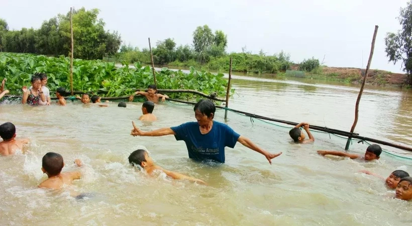 Trân Thi Kim Thia enseigne à nager des enfants dans la région de Dông Thap, dans le delta du Mékong. Photo: congthuong.vn