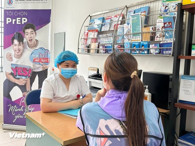 Une agente de santé informe un citoyen sur le VIH/SIDA. Photo : VietnamPlus