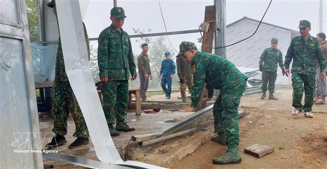 Des soldats aident des habitants de la commune de Pa Ủ (province de Lai Châu) à stabiliser leurs conditions de vie après une tempête de grêle et de forts vents survenus vers 18 heures le 17 mars. Photo: VNA