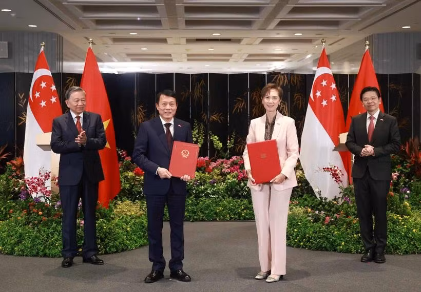 Le secrétaire général du Parti communiste du Vietnam (PCV), Tô Lâm (à gauche), et le Premier ministre singapourien, Lawrence Wong (à droite), assistent à l'échange d'un protocole d'accord sur la transformation numérique entre le ministère vietnamien de la Sécurité publique et le ministère singapourien du Développement numérique et de l'Information, le 12 mars. Photo : VNA