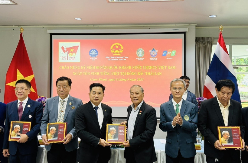 Des ressortissants vietnamiens reçoivent une copie du livre bilingue "L'Oncle Hô en Thaïland". Photo: VNA