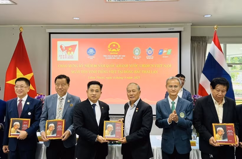 Des ressortissants vietnamiens reçoivent une copie du livre bilingue "L'Oncle Hô en Thaïland". Photo: VNA