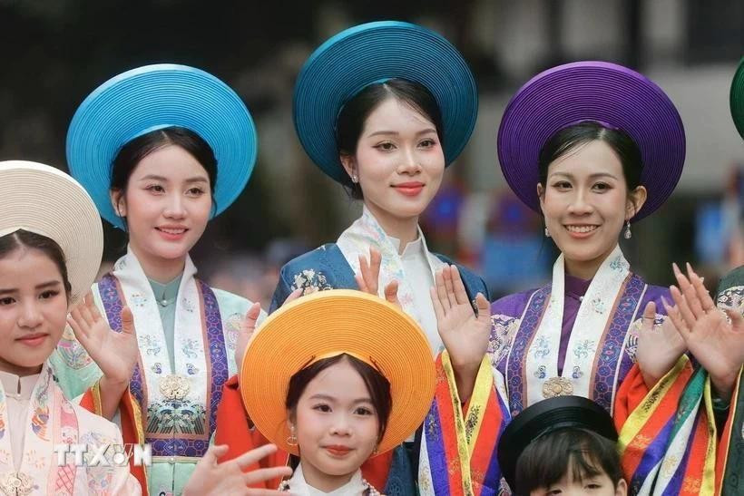 Des femmes et des enfants dans leur ao dài, la tunique longue et gracieuse que chaque vietnamienne porte à tout âge. Photo : VNA