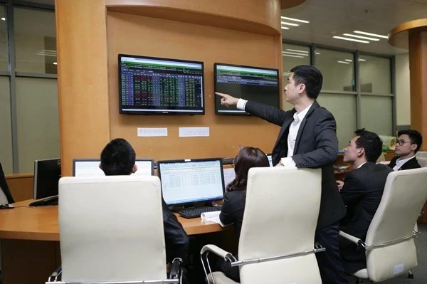 Des traders travaillent dans une salle des marchés d'une société de valeurs mobilières. Photo: VNA