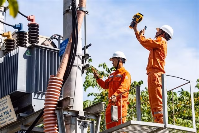 Des techniciens d'EVN effectuent des travaux de maintenance sur un transformateur à Thanh Trì, Hanoi. Photo : VNA