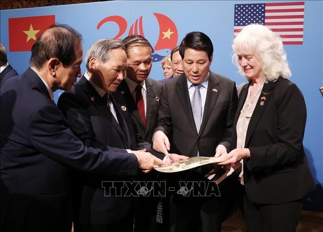 Le président Luong Cuong et les vétérans et les familles des vétérans vietnamiens et américains voient des souvenirs et des documents. Photo: VNA
