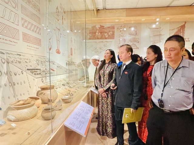 Des visiteurs admirent des artefacts mis au jour sur le site archéologique de Vuon Chuôi, au Musée de Hanoi. Photo : VNA