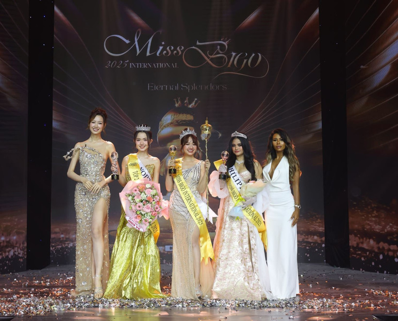 Trân Mai Thuy Vy (centre) et ses deux dauphines, entourées de deux membres du jury du concours de beauté Miss Bigo 2025. Photo : baotintuc.vn