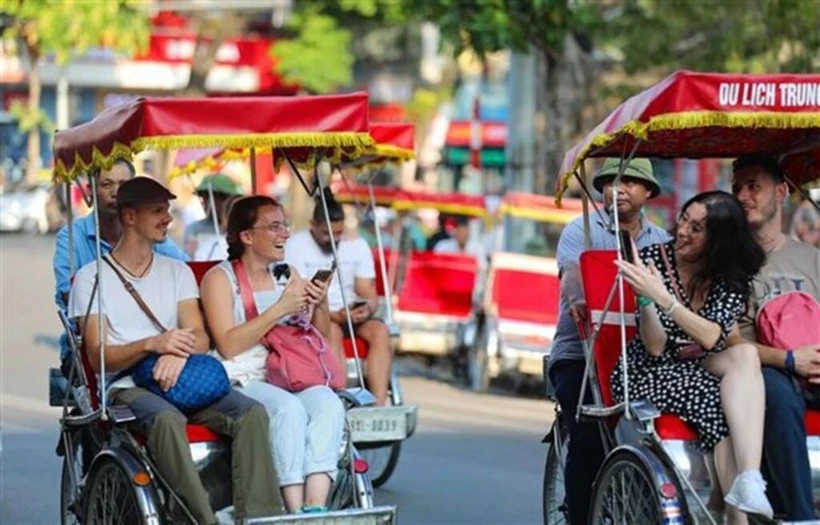 Des touristes étrangers prennent un cyclo-pousse pour découvrir le Vieux quartier de Hanoi. Photo : VNA