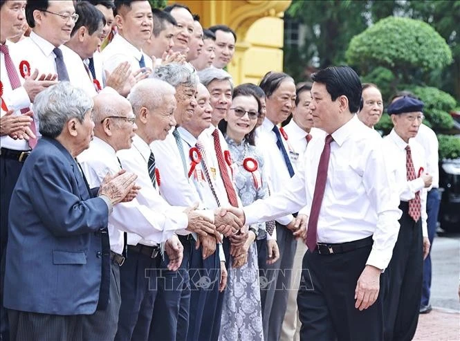 Le président Luong Cuong serre la main des journalistes chevronnés, à Hanoi, le 20 juin. Photo : VNA