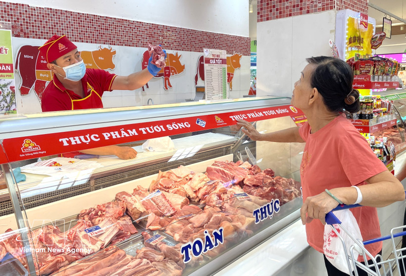 Une femme achète de la viande du porc dans un rayon de Vissan au supermarché Co.opmart Ly Thuong Kiêt, à Hô Chi Minh-Ville. Photo: VNA