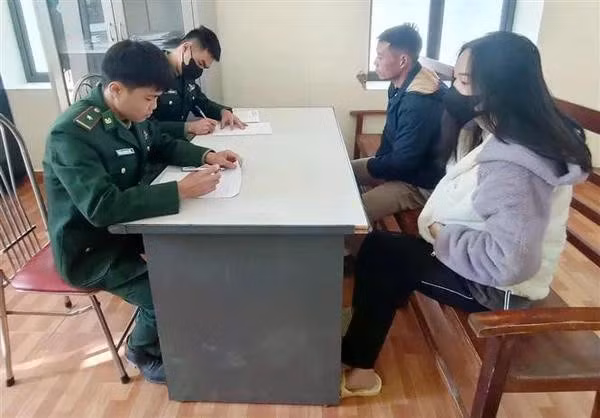 Và A Chứ (2e, à droite), arrêté pour organisation de l’immigration illégale, devant les enquêteurs. Photo : VNA