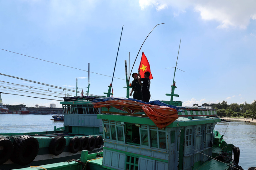 Le poste de garde-frontière de Son Trà (commandement des garde-frontières de la ville de Dà Nang) présente le drapeau national aux bateaux de pêche. Photo : VNA