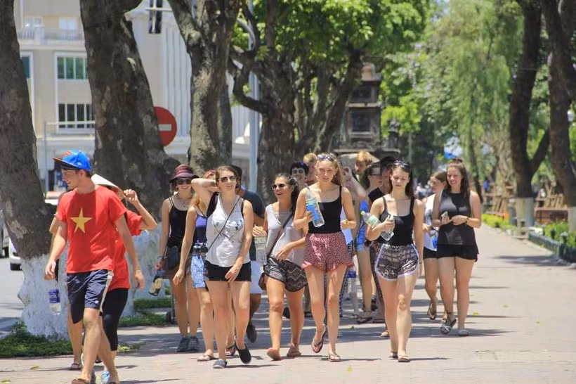 Des touristes étrangers sous un soleil ardent à Hanoi. Photo : VTC News