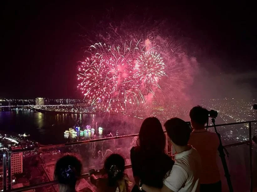 Des touristes regardent un feu d’artifice dans la ville de Dà Nang. Photo : VNA