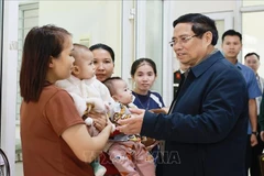 Le Premier ministre Pham Minh Chinh et des habitants se rendent au centre de santé communal de Yen Khuong pour un examen et des soins médicaux. Photo : VNA