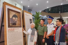 L’ancienne prisonnière politique Lê Tu Câm, émue, contemple son portrait restauré par numérisation et réalisé à partir de feuilles de lotus, exposé au Musée de Côn Dao. Photo : qdnd.vn.
