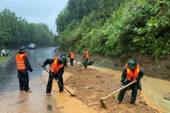 Les gardes-frontières de la ville de Hue creusent des rochers et de la terre, nivelant la surface de la route touchée par un glissement de terrain au col de Pe Ke, commune d'A Luoi 1. Photo : VNA