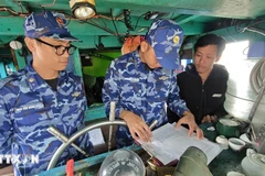 Des garde-côtes vietnamiens de la Zone 2 sensibilisent les pêcheurs au respect des réglementations relatives à la lutte contre la pêche illicite, non déclarée et non réglementée. Photo : VNA