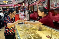Un client achète des bijoux en or dans une boutique d'or de l'arrondissement de Hai Bà Trung, ​​Hà Nội. Photo VNA