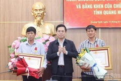 Le président du Comité populaire de la province de Quang Ngai, Nguyên Hoàng Giang, remet la Médaille du Courage du Président de la République à deux citoyens de Ly Son. Photo : VNA