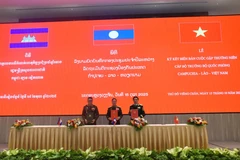 Les ministres de la Défense du Vietnam, du Laos et du Cambodge signent le compte rendu de leur réunion annuelle à Vientiane, le 15 octobre. (Photo : VNA)