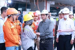 Le Premier ministre Pham Minh Chinh (deuxième à partir de la droite) adresse ses vœux de Nouvel An aux ouvriers du chantier de construction du Terminal 3 de l'aéroport international Tan Son Nhat à Ho Chi Minh-Ville. (Photo : VNA) 