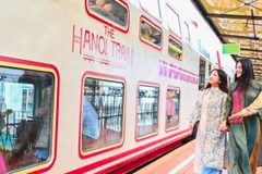 Des touristes testent le train à cinq portes, une nouvelle attraction touristique d'Hanoï. Photo : nhandan.vn