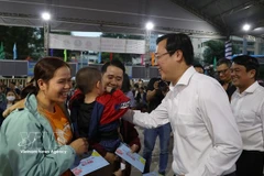 Lê Quôc Phong, secrétaire adjoint permanent du Comité du Parti de Hô Chi Minh-Ville, distribue des cadeaux aux travailleurs avant leur départ en bus pour rentrer chez eux le 12 février. Photo : VNA