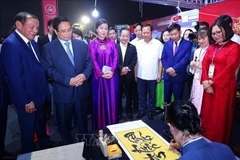 Le Premier ministre Pham Minh Chinh visite un stand vietnamien lors de l'événement (Photo : VNA)