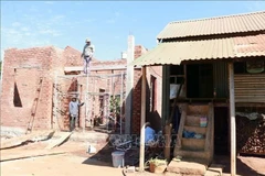 Une nouvelle maison est progressivement achevée à côté de l'ancienne maison de la famille de Ksor, un ménage pauvre du village de Mai, commune d'Ia Hrung, Gia Lai. (Photo : VNA)