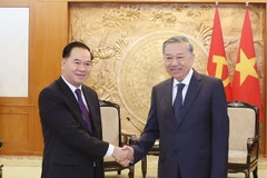 Le secrétaire général du Comité central du Parti communiste du Vietnam (PCV), To Lam (droite) et Thongsalith Mangnomek, secrétaire du Comité central du Parti populaire révolutionnaire lao (PPRL), président du Bureau du Comité central du PPRL. Photo : VNA