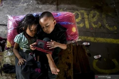 Deux enfants jouent avec un gadget à Jakarta. (Photo : ANTARA)