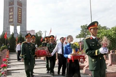 Cérémonie de réinhumation de 76 dépouilles de soldats volontaires et d'experts vietnamiens morts au Laos. Photos : VNA