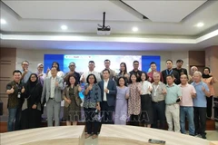 Des représentants d'entreprises vietnamiennes et indonésiennes prennent une photo souvenir avec les organisateurs du forum. Photo : VNA