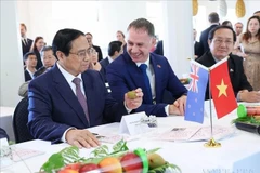 Le Premier ministre Pham Minh Chinh avec des produits de l'Institut néo-zélandais de recherche sur les plantes et les aliments. Photo : VNA