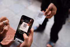 Un client effectue un paiement par QR code dans un café. Le ministère des Finances a proposé une nouvelle réglementation concernant les seuils de revenus imposables pour les entreprises à domicile. Photo : VNA