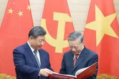 To Lam a respectueusement offert à Xi Jinping un album photo de l'Agence vietnamienne d’Information, présentant des clichés représentatifs et impressionnants de ses cinq visites au Vietnam depuis 2011. Photo : VNA